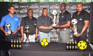  Petra Organisation Troy Mendonca (centre) receives the winning trophy from Guinness Brand Manager Lee Baptiste in the presence of Banks DIH officials yesterday.