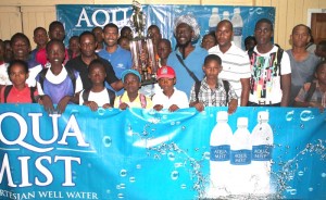 Commander of ‘A’ Division, Clifton Hicken (second, 2nd row) and Aqua Mist Brand Manager, Errol Nelson (on his left), hand over the winning trophy and prize to East Ruimveldt.