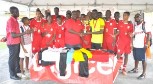 Digicel’s Sponsorship and Events Manager Gavin Hope hands over the winning trophy to regional champions Christianburg / Wismar Captain in the presence of teammates and coaches yesterday at Wisburg ground.