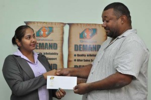 TCL Accountants Clerk, Ms. Nirmala Ganga hands over the cheque to RHTY&SC Secretary/CEO Hilbert Foster. 