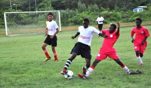 Players from BEI (white jersey) and Vrymen’s Erven fight for possession of the ball in their clash yesterday at Burnham Park in Berbice. 