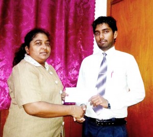 Representative Trevor Ramdeholl receives sponsorship cheque from Mrs Priyta Rampersaud, Manager Berbice area for Sentinel Security Inc. 