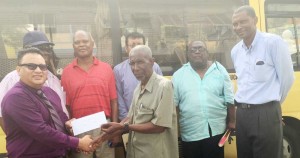 Bissoondyal Singh (left) hands over sponsorship cheque to Malcolm Peters in the presence former West Indies V/Captain, Roger Harper (extreme right), former national selectors Claude Raphael (2nd right) and Albert Smith (3rd left) and others. 
