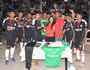 Captain of reigning champions Annai Garville Daniels receives the winning trophy from Digicel Representative Madella Mohabir in the presence of fellow staffer Seon Chapman and teammates on Monday.