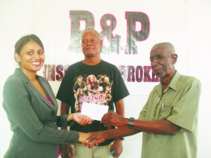 Malcolm Peters, former GCB Vice President and former BCB President, receives the sponsorship cheque from P&P Accounts Executive Mrs Melinda Sammy-Alli in the presence of former national coach and chairman of senior selectors Albert Smith. 