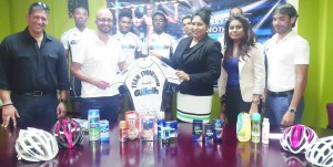 Ansa McAl Procter and Gamble Manager  Ms. Nafeeza Khan-Chand (4th right) hands  over one of the jersey’s to Gillette Evolution  Club President, Keith Fernandes in the  presence of other officials and cyclists.    