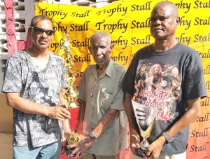 Ramesh Sunich (left) hands over one of the trophies to Malcolm Peters in the presence of Albert Smith.  