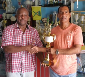 Manager of Trophy Stall Ramesh Sunich (right) hands over the Mr. Gym Expo overall trophy to Donald Sinclair of Fitness Express.