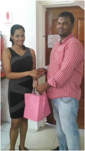 DeSinco Marketing Director Alicia  DeAbreau hands over hampers to RHTYSC Member Mark Papannah.