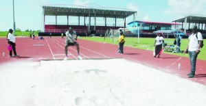 ‘A’ Division’s Yoel Benjamin descends into the pit yesterday in the triple jump competition.