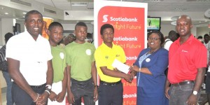Scotiabank relationship officer Karen Harris presents the cheque to Alphius Bookie in the presence of manger Brian Hackett (right), DCC head Alfred Mentore (left), Sachin Singh and Qumar Torrington. 