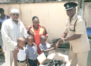 ‘A’ Divisional Officer (right), donating shoes to Albouystown Nursery School.