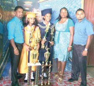 The two top students, Roxanna Singh and Shaniya English, flanked by their teachers, Sir Kampta Persaud (left) and Miss Odessa Dundas, along with ESG Steering Committee Member Videsh Lall.   