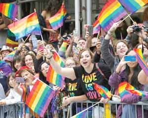 Spectators waving rainbow flags at a New York City Gay Pride parade last Sunday