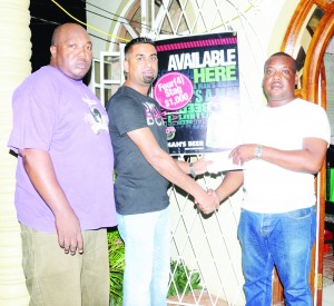 Captain of the victorious TNT team Ryan Boodhoo (center) accepts the first placed prize from Timothy Fisher of Serenity Restaurant and bar in the presence of Dion Carter. 