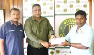 GCB Treasurer, Anand Kalladeen (centre) hands over the cheque to GYO President, Surendra Heeralall, in the presence of GCB Secretary, Anand Sanasie.