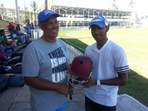 Former First-Class player Huburn Evans (left) presents the Helmet to Omrao on behalf of the donor. 