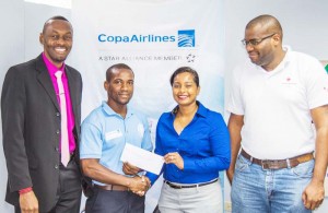  From Left Director of Sports, Christopher Jones, looks on as Director of Tang Soo Do International Guyana Roland Eudoxie collects the tickets from COPA Airlines Country Sales Manager Nadine Oudkerk as the Red Cross rep observes.