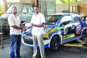 Young Group 1 racer Javid Rahaman (left) receives sponsorship from Faiaz Ali of Two Brothers Gas Station and Gulf Motor Oil at the team’s Garage on Friday. 