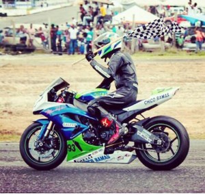 Young Superbike racer Kevin Persaud displays the chequered flag astride his 2011 Kawasaki ZX6R.