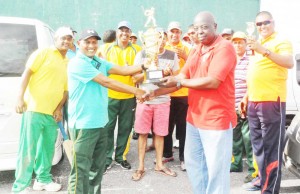 Captain of the victorious Regal team Mahase Chunilall (left) accepts the trophy from GSCL Inc President Ian John. 