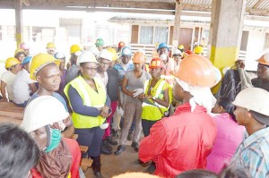 Minister Broomes (third from left) interacting with  workers of the Barama Buckhall operations.