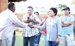 Minister within the Ministry of Indigenous Peoples’ Affairs Valerie Garrido-Lowe gives contractor Colin Andrews a ceremonial handshake for delivering the new village.