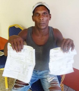 Aftab Persaud displays the receipts for the items carried away by the robbers.