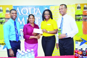 Jennifer Khan of Banks DIH Limited makes the presentation to Roberta Ferguson of Courts Guyana Inc. in the presence of Errol Nelson (left) and Aubrey Hudson.