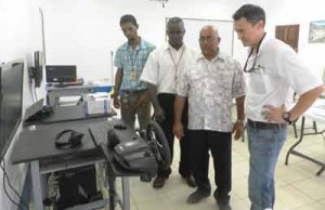 Farmsup Operations Manager Shelte Van Dijk, Principal of LTI Dennis Jaikarran and the two trainers for the heavy duty equipment training programme inspect one of the simulators.