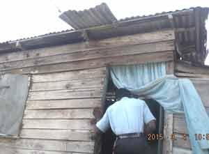 A police rank enters a shack where electricity theft is suspected