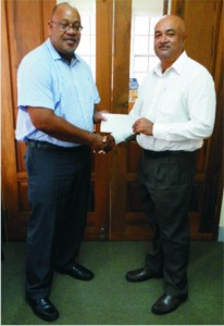 Marketing Manager of Demerara Mutual, Clarence Perry (left), hands over the sponsorship cheque to Lusignan Golf Club President, Oncar Ramroop. 