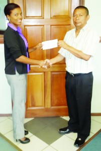 An official of the Joseph ‘Reds’ Perreira Sports Foundation Inc. hands over the cheque to President of the Guyana Volleyball Federation John Flores on Tuesday.