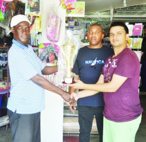 Anand Bharat (right) presents the trophy to Mark Wiltshire in the presence of David Hunte. 