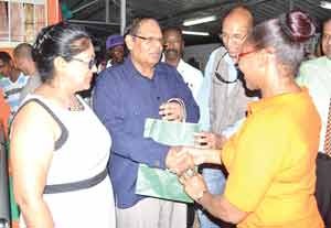 Prime Minister Moses Nagamootoo receives a gift from a staff of the Bank of Guyana in the presence of his wife Seeta when they visited the BOG booth.
