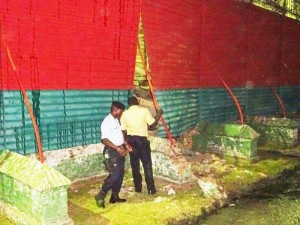 Security officers examine the gaping hole created in the Camp street Prison fence last evening.