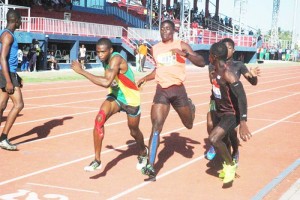 GDF’s Wayne Harlequin (left) collects the baton from Davin Fraser just ahead of Guyana Police Force’s Olympian, Winston George yesterday at Leonora. 