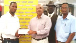  Courts Marketing Manager, Pernell Cummings (left) hands over the sponsorship cheque to President of the LGC, Oncar Ramroop. Also present are LGC officials, Guy Griffith and Patrick Prashad.