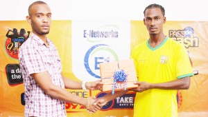 E-Networks’ Marketing Coordinator Joublon Beaton (Left) makes the presentation to Gregory ‘Jackie Chan’ Richardson for the E-Networks ‘Goal of the Month’.