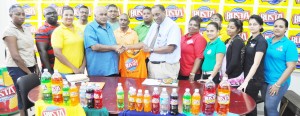 CEO of GBI Mr. Robert Selman (right of pres.) hands over one of the player jerseys to ECB President Fizul Bacchus in the presence of officials and staff members.    