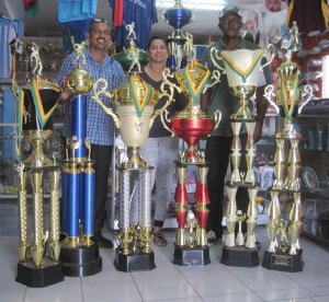 GFSCA vice president Jailall Deodass, Devi Sunich Managing Director of Trophy Stall and GFSCA organiser Wayne Jones are all smiles as they display the trophies for Guyana Softball Cup 5.