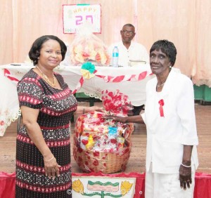 Social Protection Minister, Volda Lawrence (left)  presents a hamper to one of the club members.
