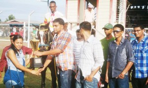 Nazrudeen ‘Junior’ Mohammed, coordinator of this meet, receives the winning trophy from a Representative of the Shariff Stable during a previous event, and has promised an exciting day of horseracing. 