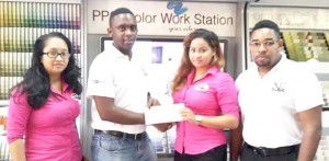 Toshanna Allicock of Bumper to Bumper hands over the sponsorship to Aubrey Major (Jr.) in the presence of Kenrick Noel and Janet Alphonso. 