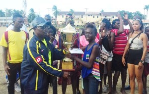 Commander of ‘A’ Division, Clifton Hicken (left) hands over the Championship Trophy to the winning Agricola Youth Group at Eve Leary.