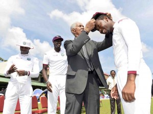 Sir Garry Sobers presents Jomel Warrican with his maiden Test cap © WICB