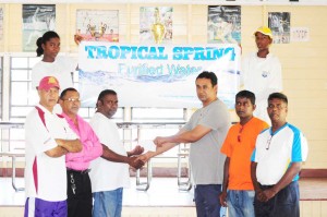 ECDCA Competitions Committee Chairman Anil Persaud (right) accepts the sponsorship cheque from Rajindra Jhun of Tropical Springs Water in the presence of other officials of the ECDCA.