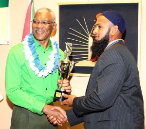 West Indies Test player Assad Fudadin receiving his award from President David Granger.