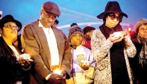 Randolph Holder Sr., the father of the slain officer killed in East Harlem last week, with Sherry Holder, the officer’s sister, second from right, at a vigil in Richmond Hill, Queens, on Saturday. 