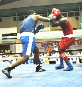 Big Trini Nigel Paul (left) was all over Guyana’s Eon Fraser as their Super Heavyweight bout was stopped in 1 min 57 seconds in the first round.